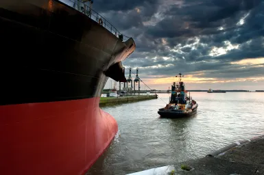 Ship and tugboat departing harbour